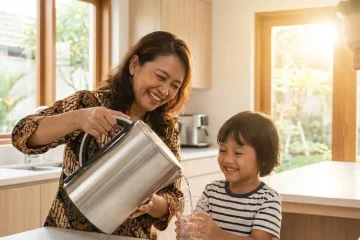 Keluarga sehat sedang minum air bersih dari filter air rumah tangga di dapur modern.