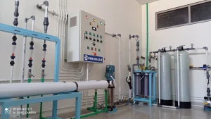 Instalasi pengolahan air dalam ruangan dengan flow meter, pompa, tangki filter, dan panel kontrol